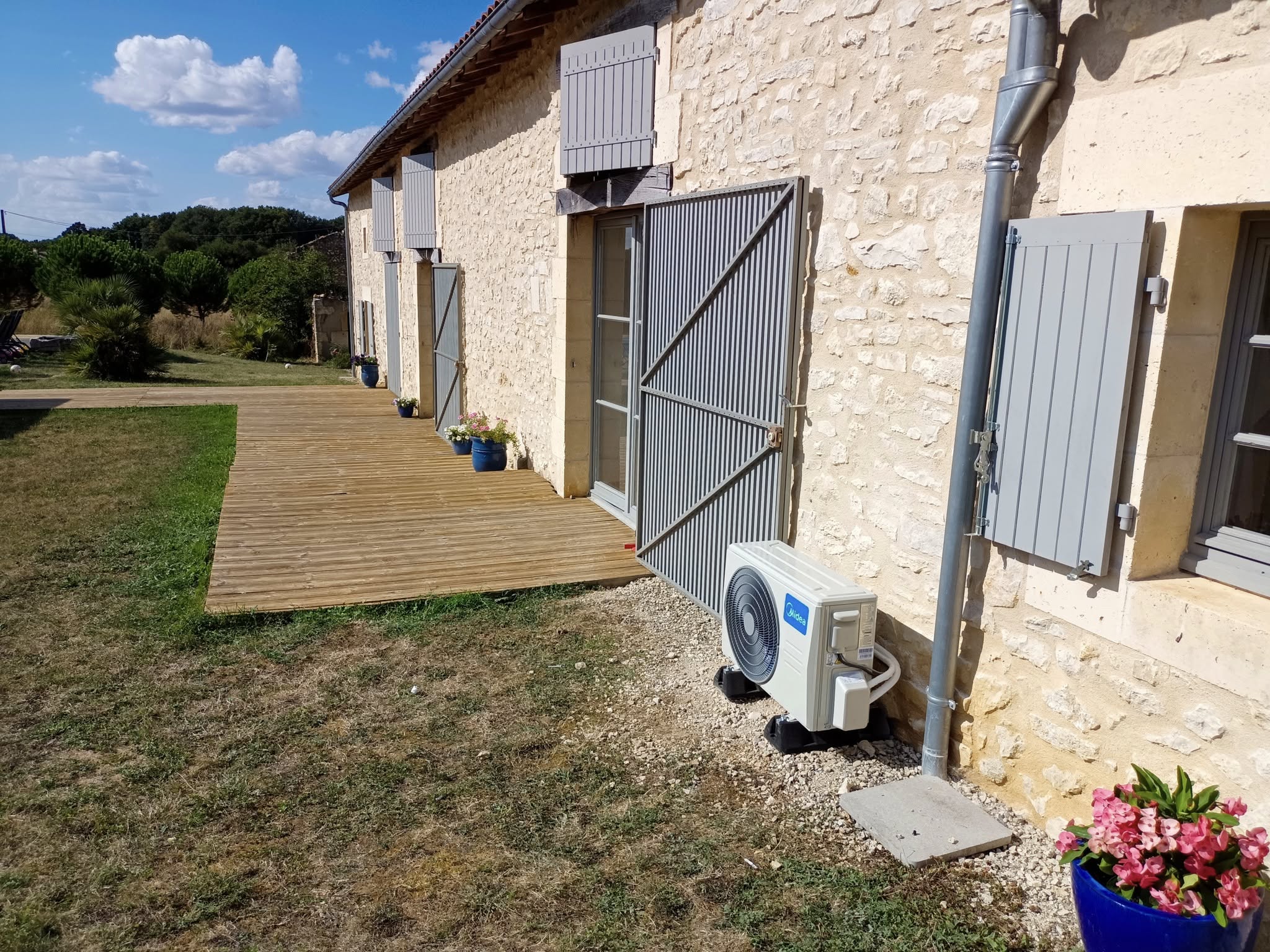 Groupe extérieur Midea maison en pierre