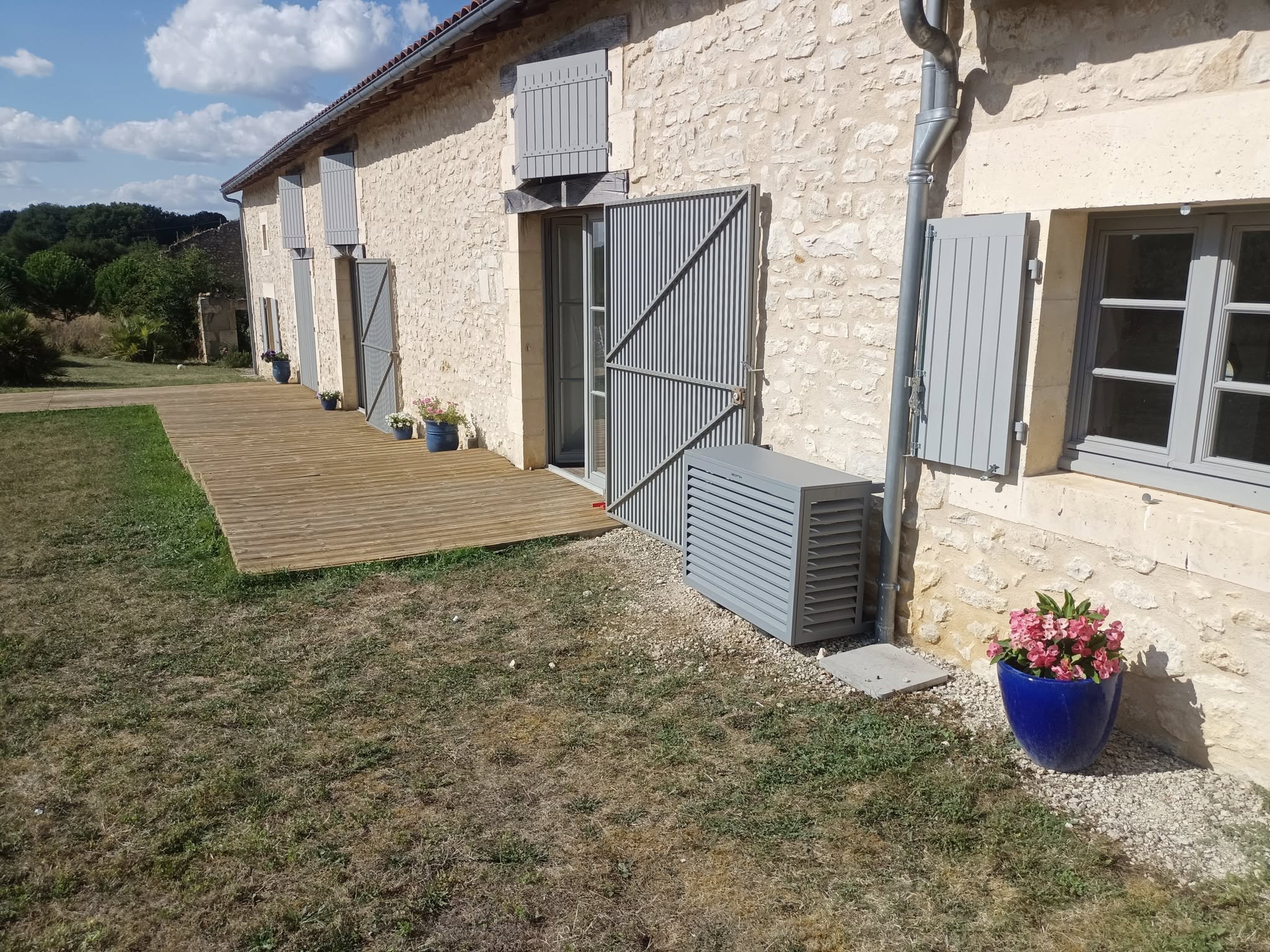 Cache climatisation sur maison en pierre